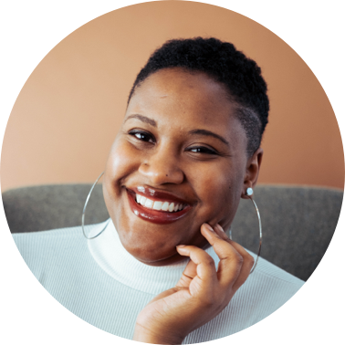 Smiling women with big loop earrings holding her hand to her cheak