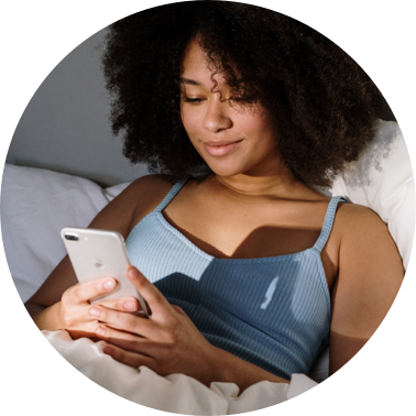 Woman lying in bed looking at her phone